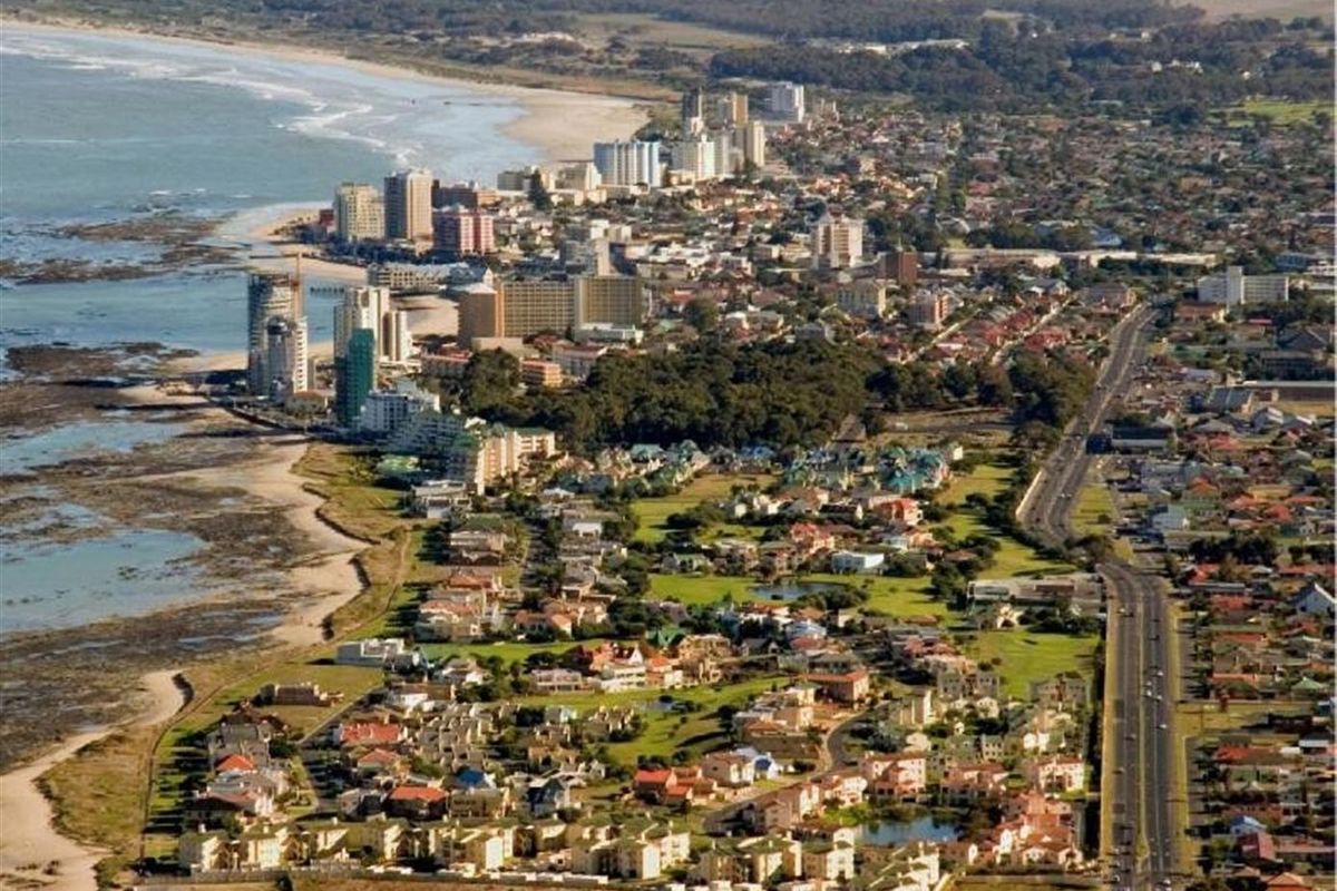 An expansive aerial view of the coastal town, showcasing the proximity to the beach, local infrastructure, and surrounding residential landscape.