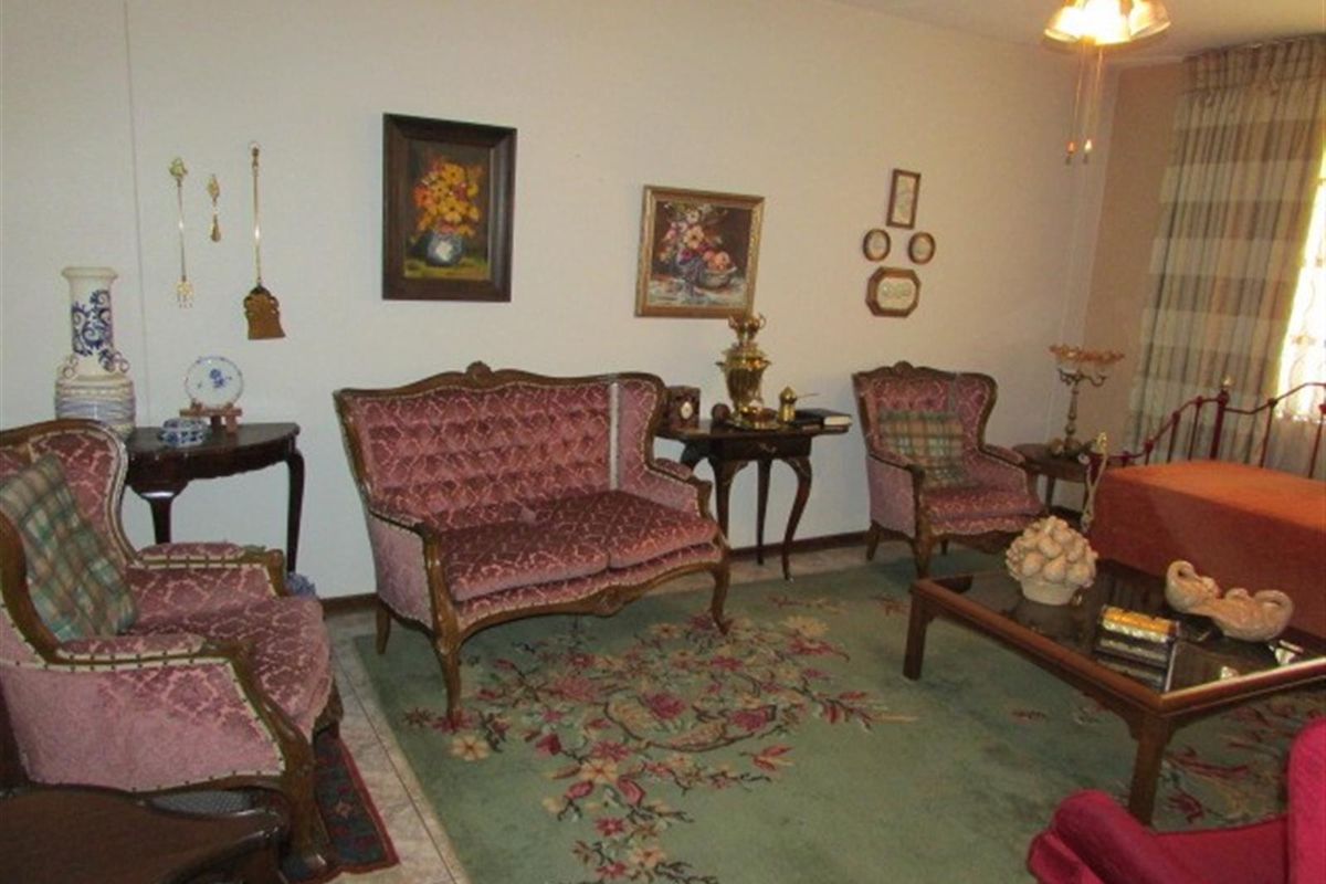 A traditional living room featuring tiled flooring and a ceiling fan, offering a comfortable and classic living space.
