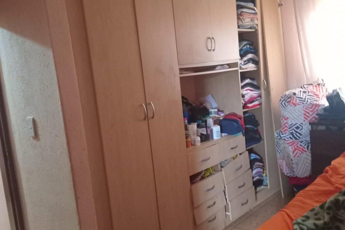 A bedroom featuring extensive built-in wooden cabinetry with integrated shelving and drawer storage units.