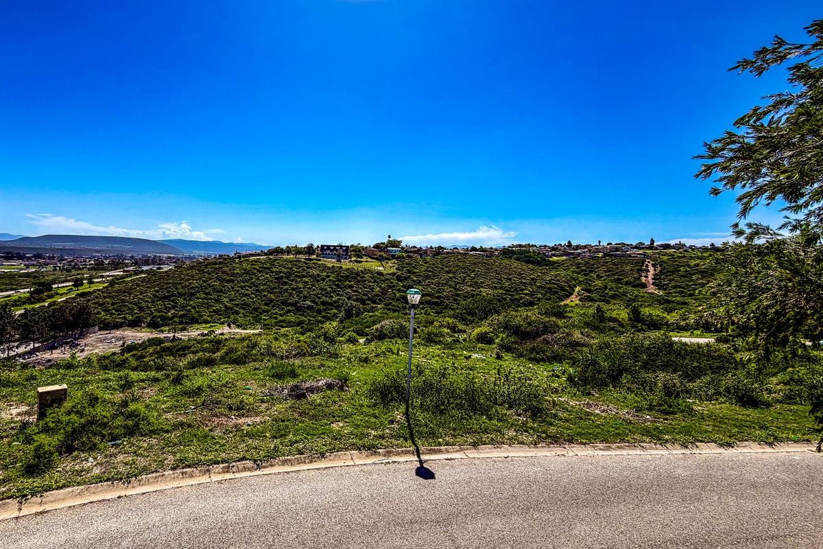A view of the vacant residential land featuring natural vegetation, rolling hills, and a clear sky, showcasing the property's landscape and surrounding area.