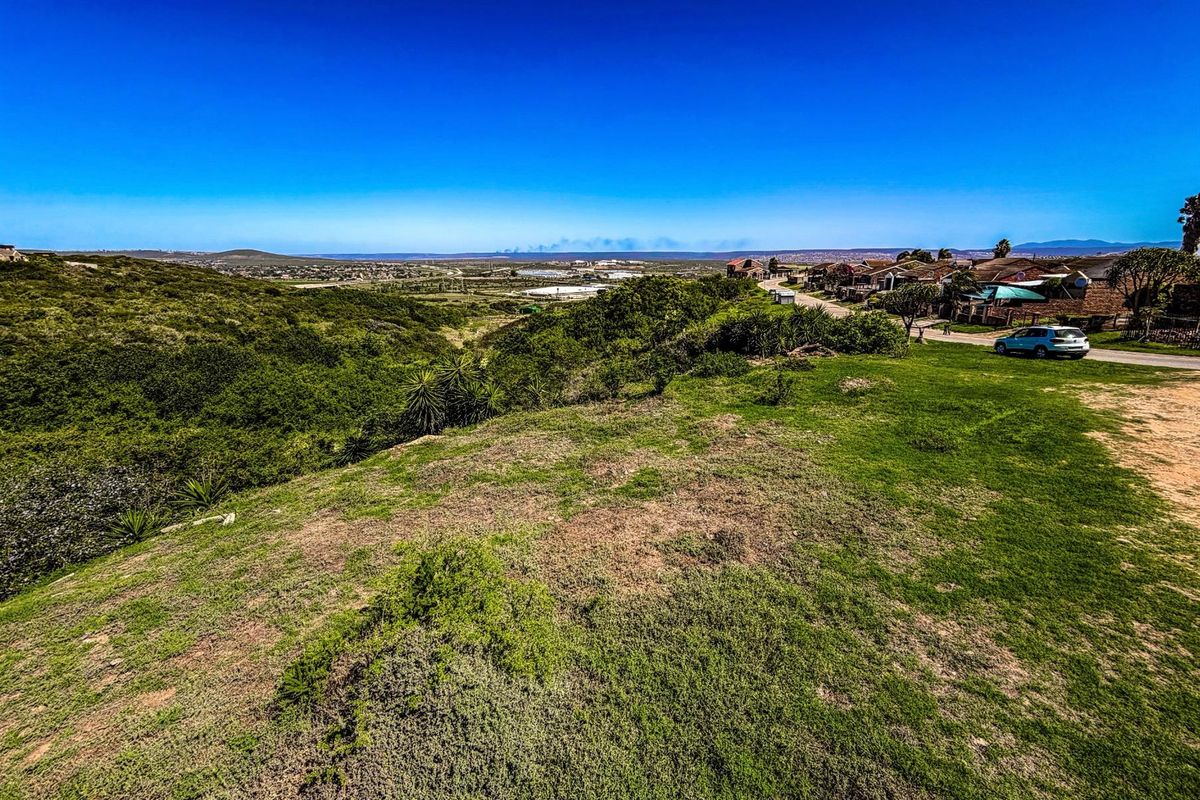 A scenic view overlooking a natural landscape with surrounding residential development and distant horizon.