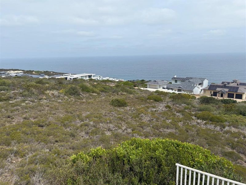 Elevated coastal view overlooking the surrounding neighborhood and ocean horizon, showcasing the property's scenic location.