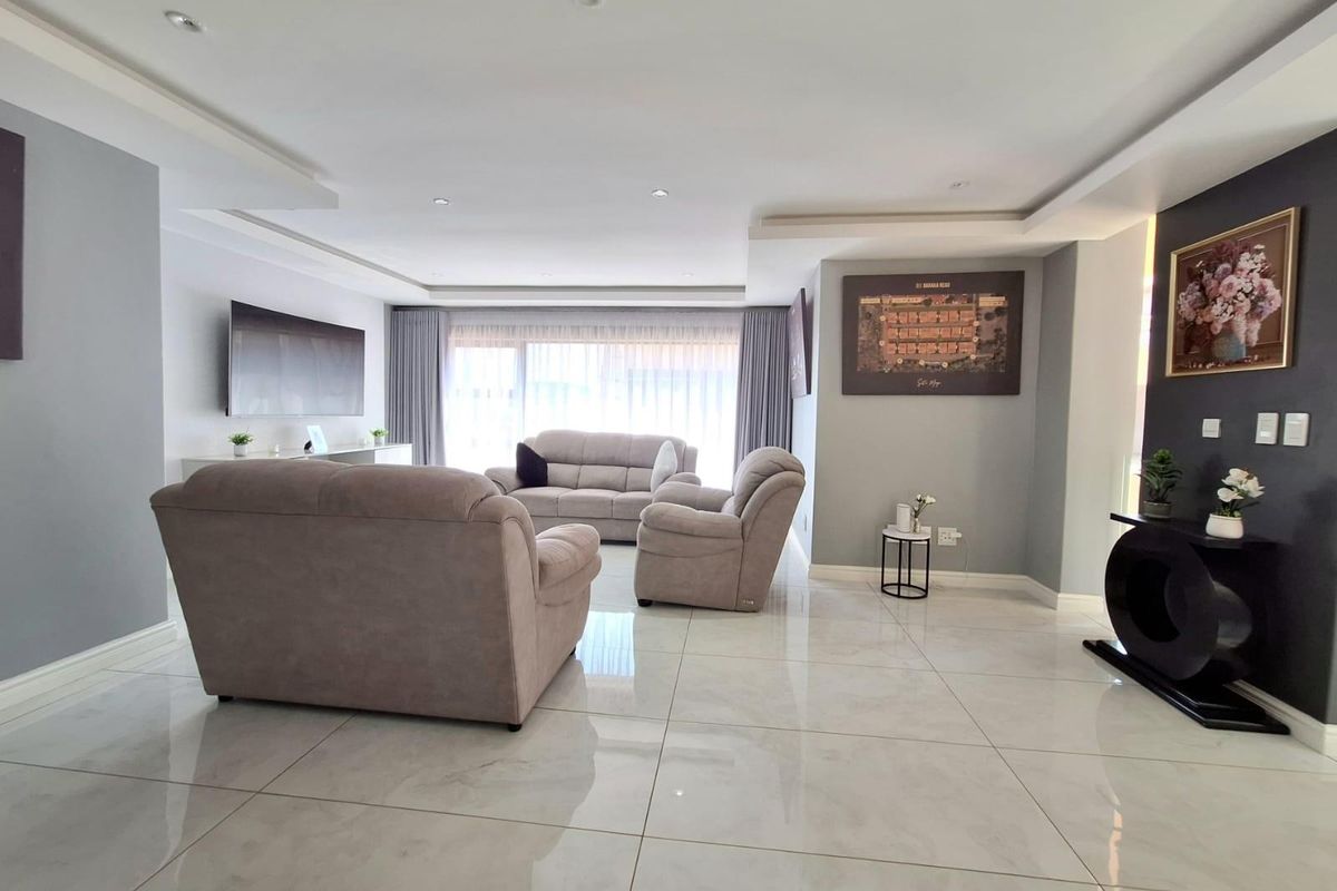 Spacious living room featuring polished porcelain floor tiles, recessed ceiling lighting, and a modern neutral color palette.