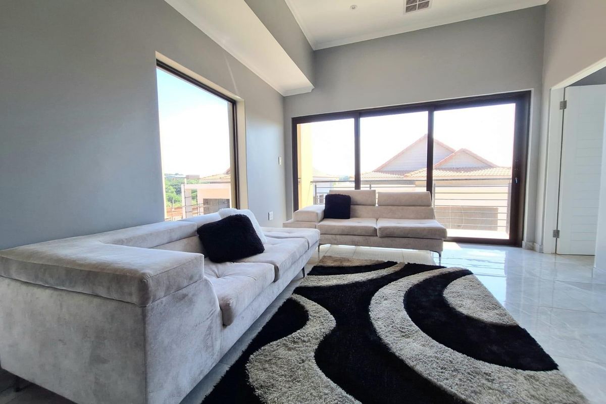 Spacious living area featuring high ceilings, large windows, and sliding glass doors that provide ample natural light and access to the exterior.