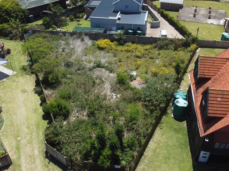 Aerial view of a vacant residential plot featuring established perimeter fencing and surrounding residential properties.