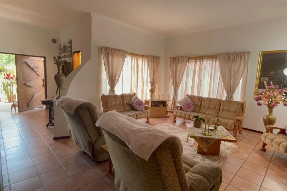 Spacious living room featuring tiled flooring and large windows that allow for ample natural light, creating a warm and inviting atmosphere.