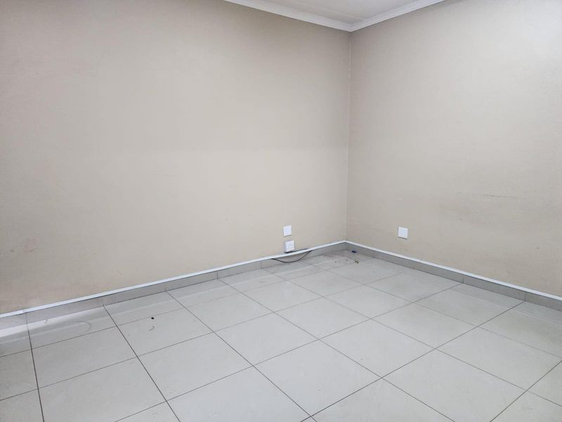 A vacant, neutral-toned office or bedroom space featuring tiled flooring and standard electrical points, ready for customization.