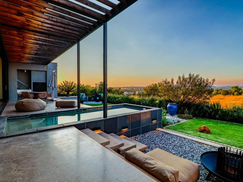 Stunning outdoor entertainment area featuring a modern swimming pool, timber pergola, and landscaped garden with panoramic sunset views.