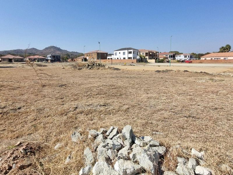 A wide-angle view of a vacant residential plot in a developed neighborhood, ready for new construction.