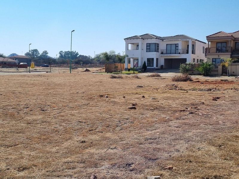 A vacant residential plot situated in a developed neighborhood, featuring level ground and established boundary infrastructure.