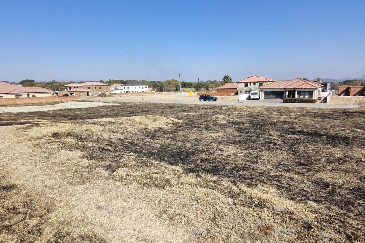 A vacant residential plot of land situated in a developed neighborhood with surrounding houses.