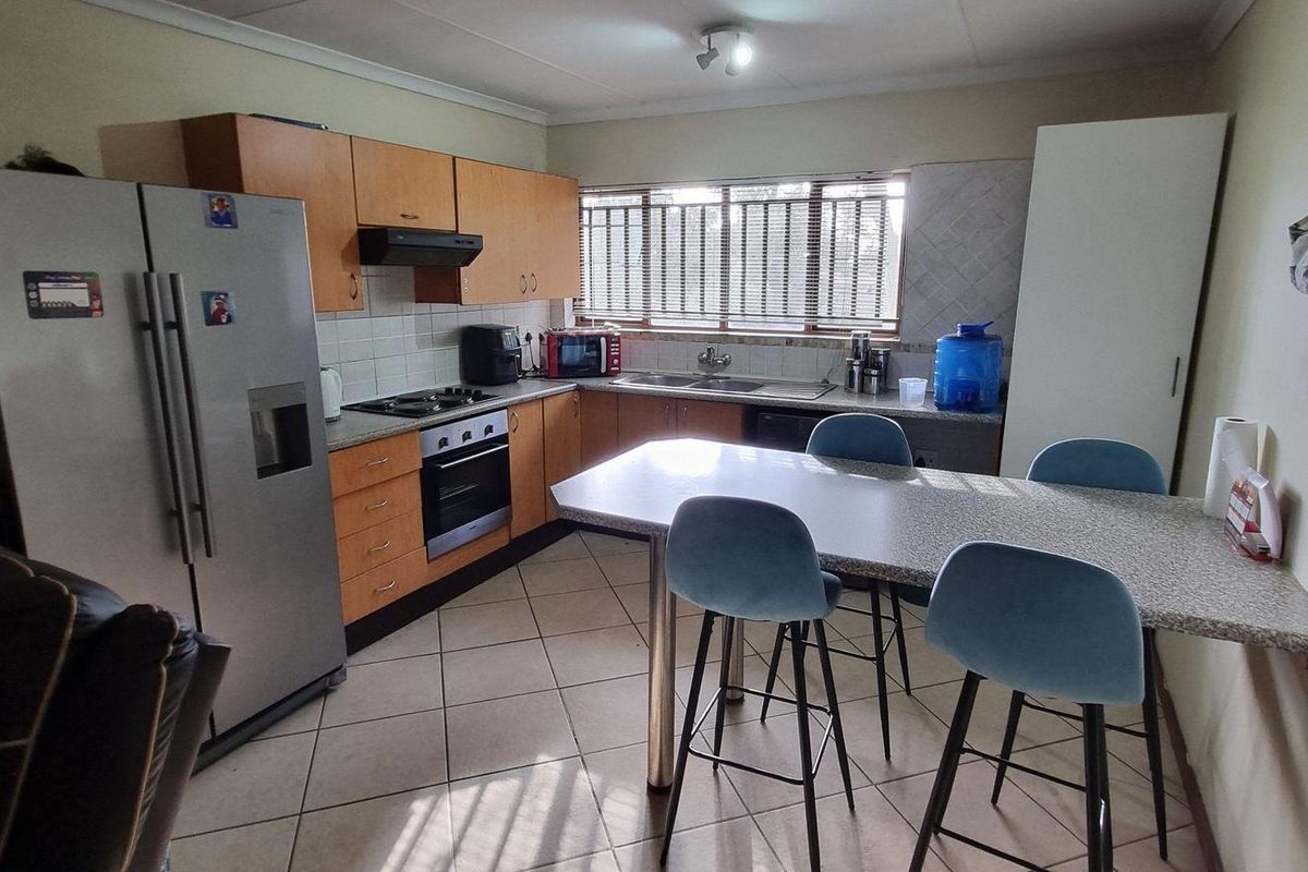 A functional kitchen featuring built-in cabinetry, laminate countertops, a built-in oven with hob, and tiled flooring, offering a practical layout for daily use.