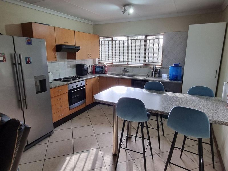 A functional kitchen featuring built-in cabinetry, laminate countertops, a built-in oven with hob, and tiled flooring, offering a practical layout for daily use.