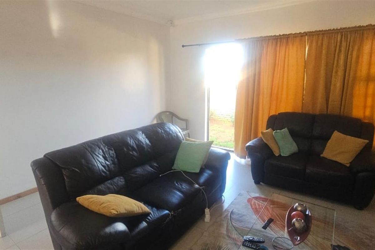 A living room featuring tiled flooring and a sliding door providing access to the exterior.