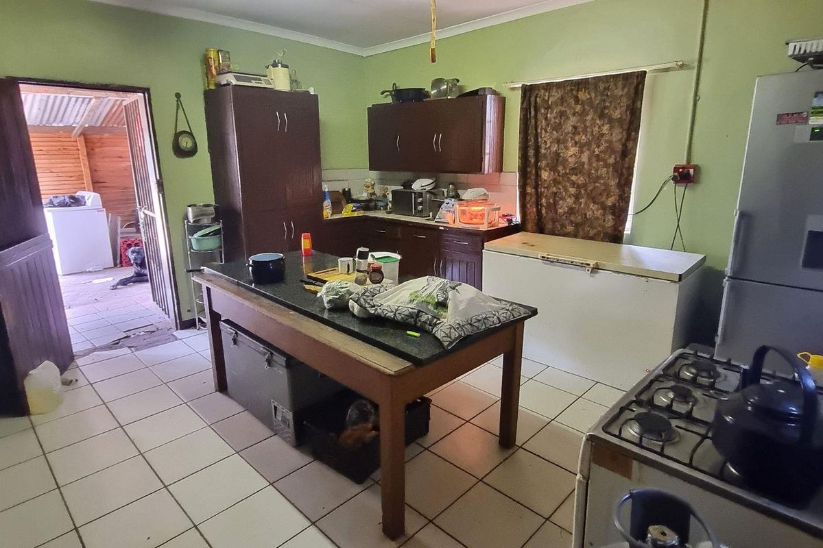 A functional kitchen featuring tiled flooring, built-in cabinetry, and a gas stove, offering potential for modernization and layout optimization.