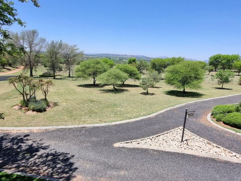 An elevated view of the expansive farm grounds featuring a well-maintained gravel driveway, manicured lawns, and mature trees.