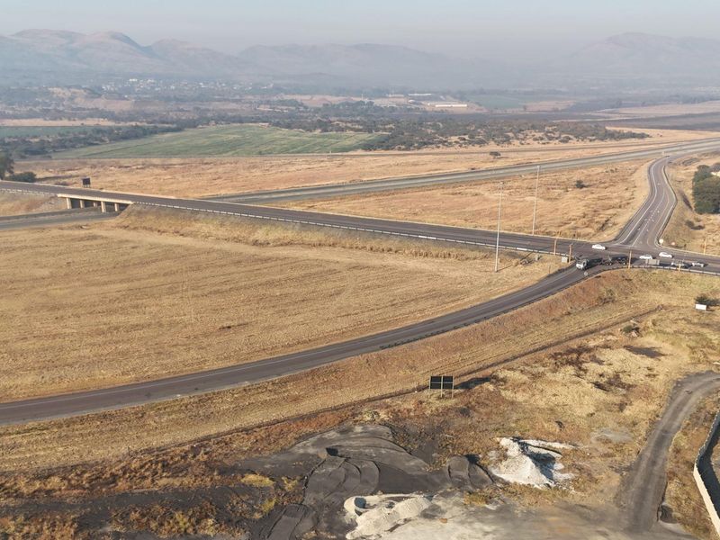 An aerial view of a rural highway intersection and bridge overpass, showcasing the surrounding landscape and road infrastructure.
