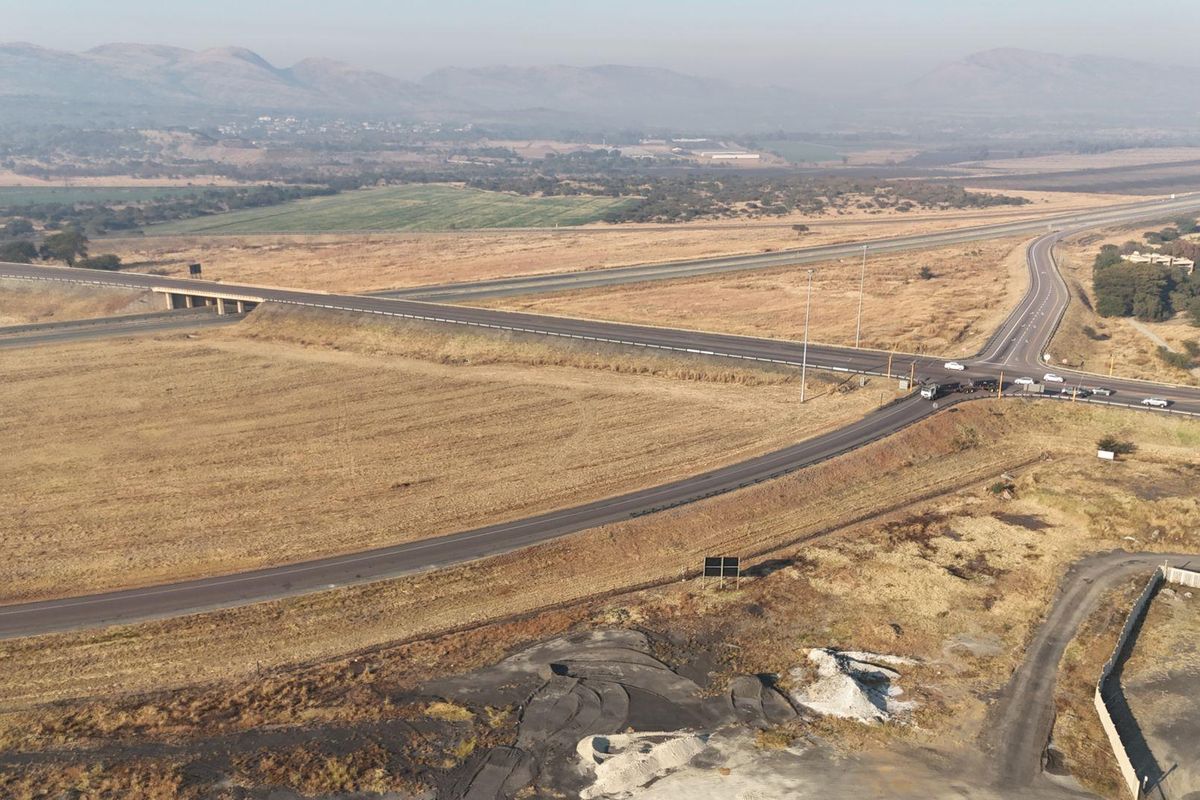 An aerial view of a rural highway intersection and bridge overpass, showcasing the surrounding landscape and road infrastructure.