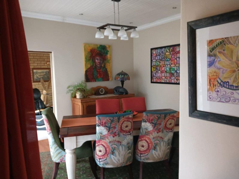 A well-maintained dining room featuring a beadboard ceiling, crown molding, and modern pendant lighting, creating a warm and inviting space for meals.