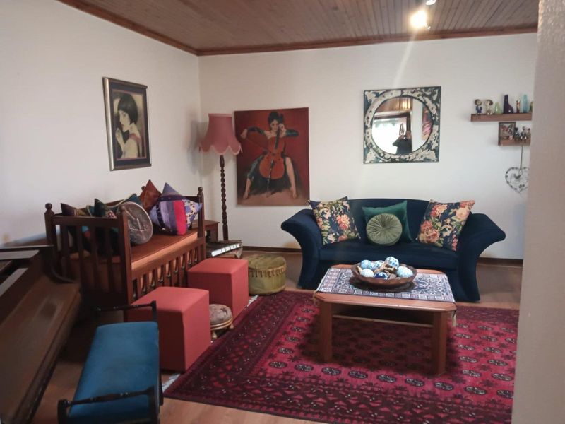 A cozy living room featuring warm timber ceiling paneling and laminate flooring, providing a comfortable and inviting space for relaxation.