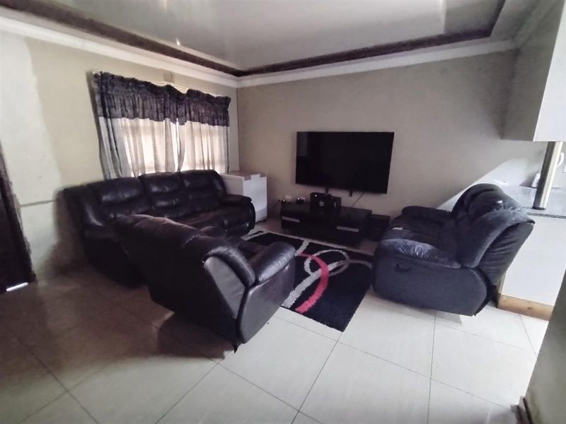 A living room featuring tiled flooring and coved ceiling details, providing a functional space for relaxation.