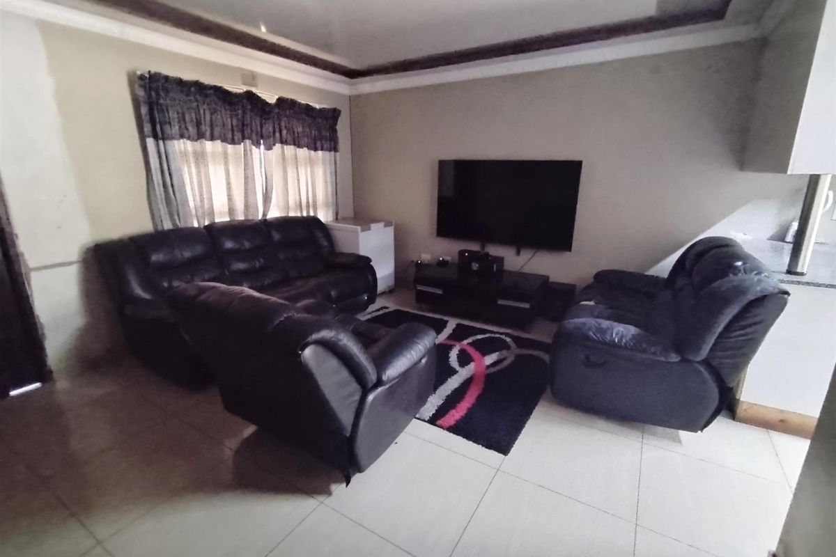 A living room featuring tiled flooring and coved ceiling details, providing a functional space for relaxation.