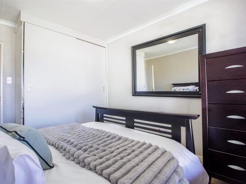 A well-maintained bedroom featuring a built-in wardrobe and neutral wall finishes, providing a clean and functional living space.