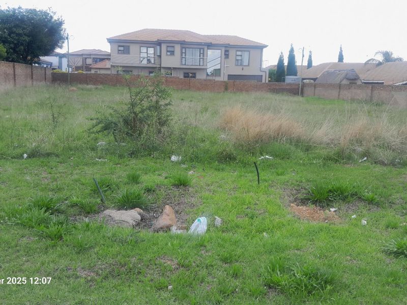 A vacant residential plot featuring perimeter brick walling, ready for development in an established neighborhood.