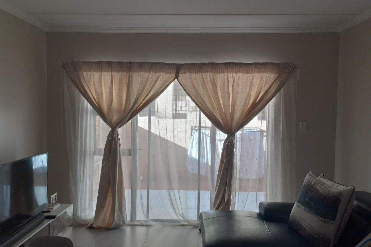 A living room featuring large sliding glass doors that provide access to an outdoor balcony area.
