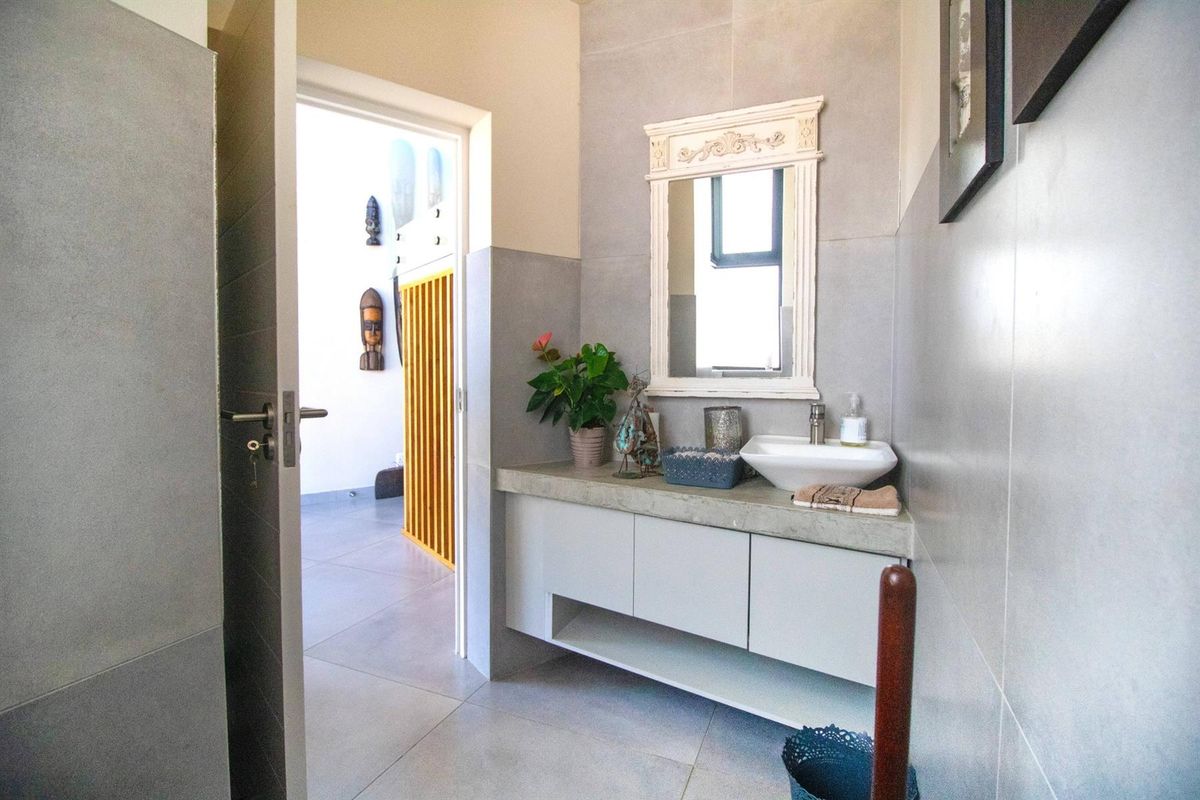 Modern bathroom featuring a floating vanity with a concrete countertop, vessel sink, and large format grey wall tiles.