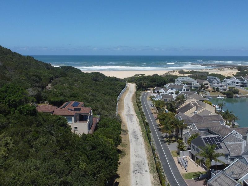 Aerial view of the residential property location, showcasing proximity to the coastline, natural vegetation, and established neighborhood infrastructure.
