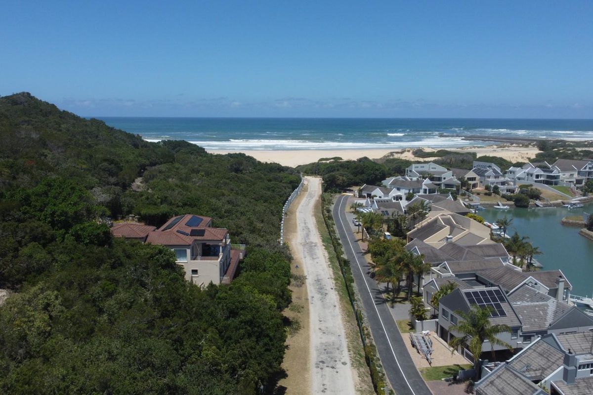 Aerial view of the residential property location, showcasing proximity to the coastline, natural vegetation, and established neighborhood infrastructure.