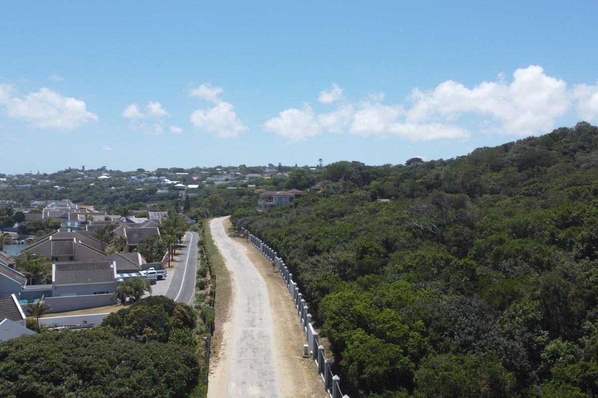An aerial view of the residential land, showcasing the surrounding neighborhood, access road, and established coastal vegetation.