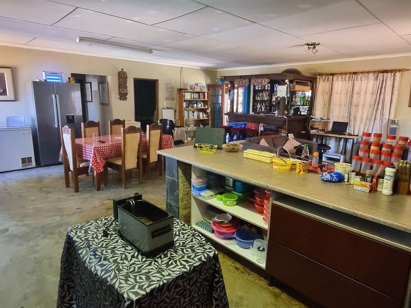 Spacious open-plan living area featuring a built-in bar, kitchen island, and drop ceiling, offering significant potential for modernization and layout optimization.