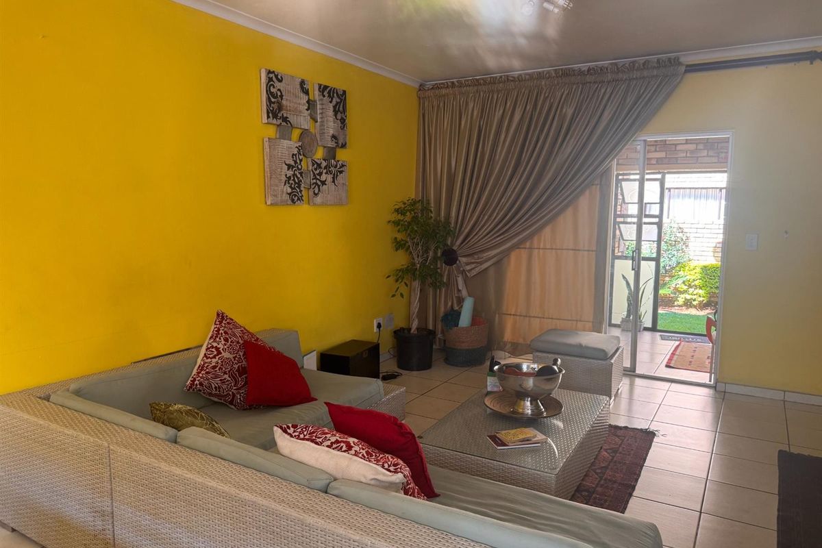 A living room featuring tiled flooring and a sliding glass door providing access to an outdoor patio area.