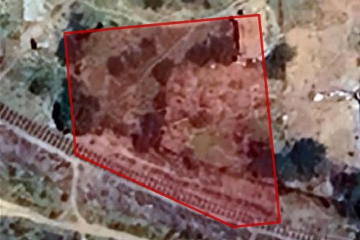 An aerial view of a vacant residential plot, highlighting the property boundaries and surrounding landscape.