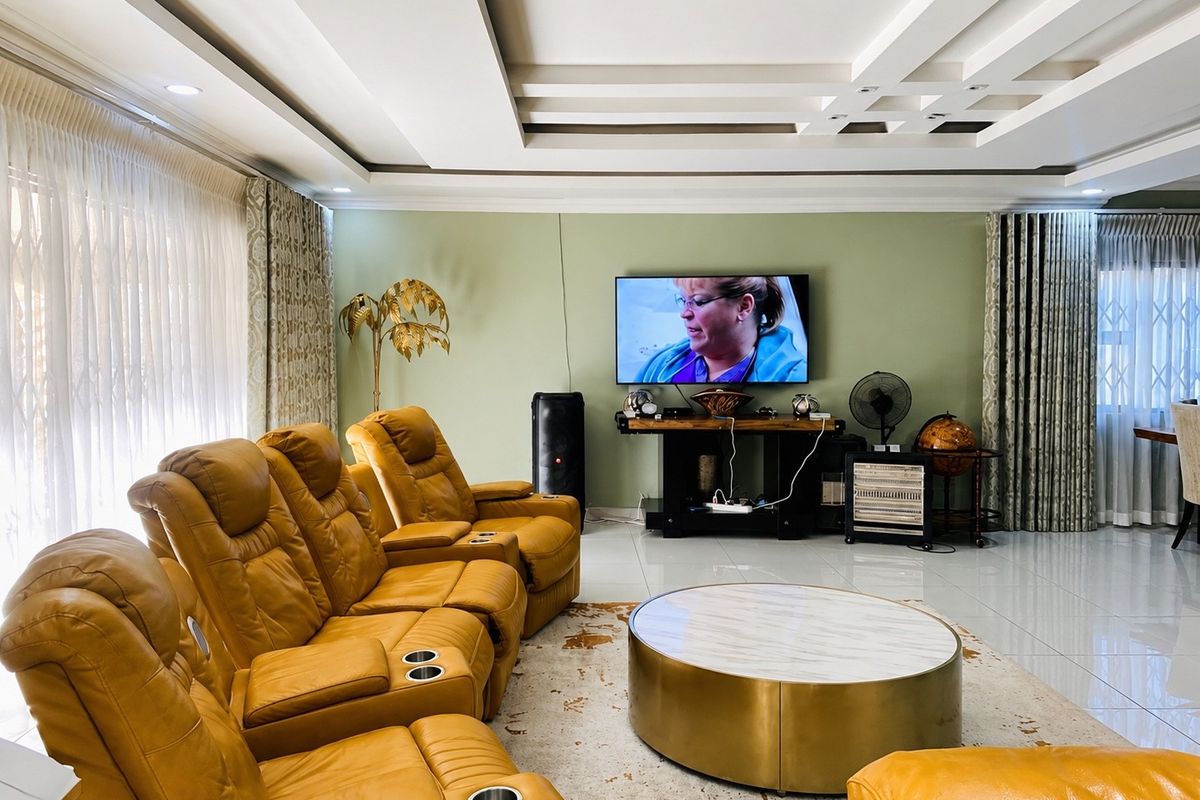 Spacious living room featuring a modern recessed ceiling design, large format floor tiles, and neutral wall tones, creating a comfortable and well-maintained living space.