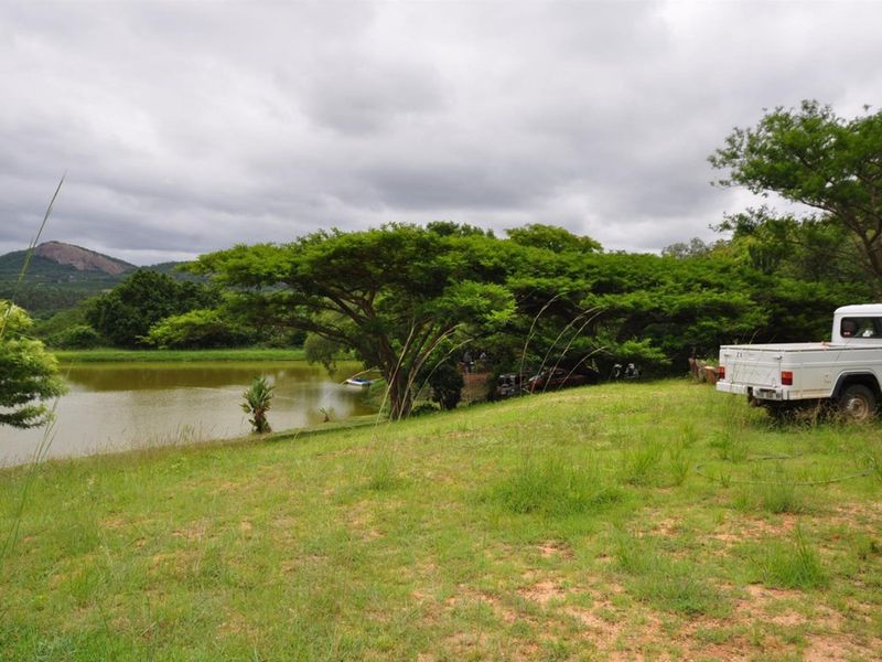 A scenic view of the property's dam and surrounding natural landscape, showcasing the tranquil outdoor environment of the small holding.