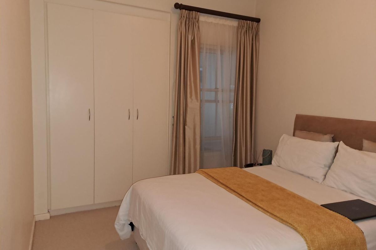 A bedroom featuring built-in cupboards and neutral carpeting, providing a functional and comfortable living space.