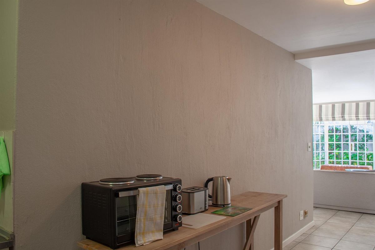 A functional kitchen area featuring tiled flooring and neutral wall finishes, providing a clean and practical space for daily meal preparation.