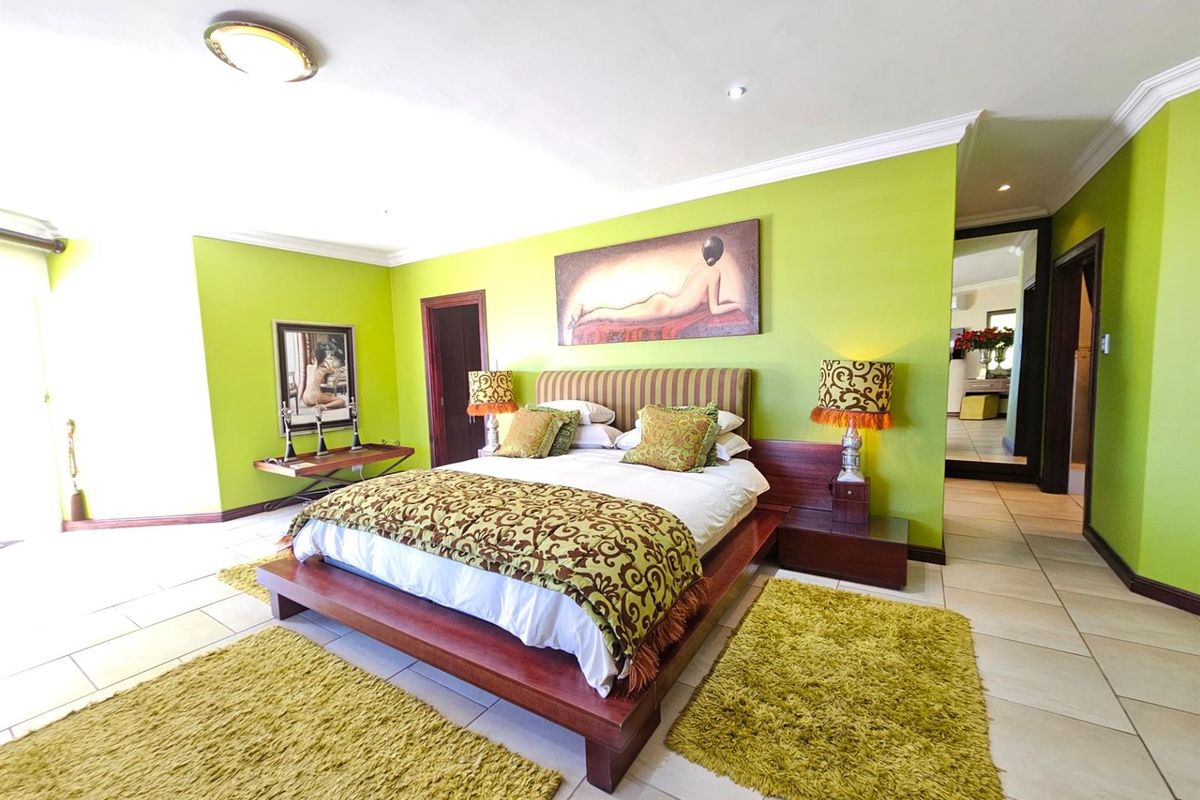 Spacious bedroom featuring tiled flooring, crown molding, and a built-in doorway leading to an en-suite area.