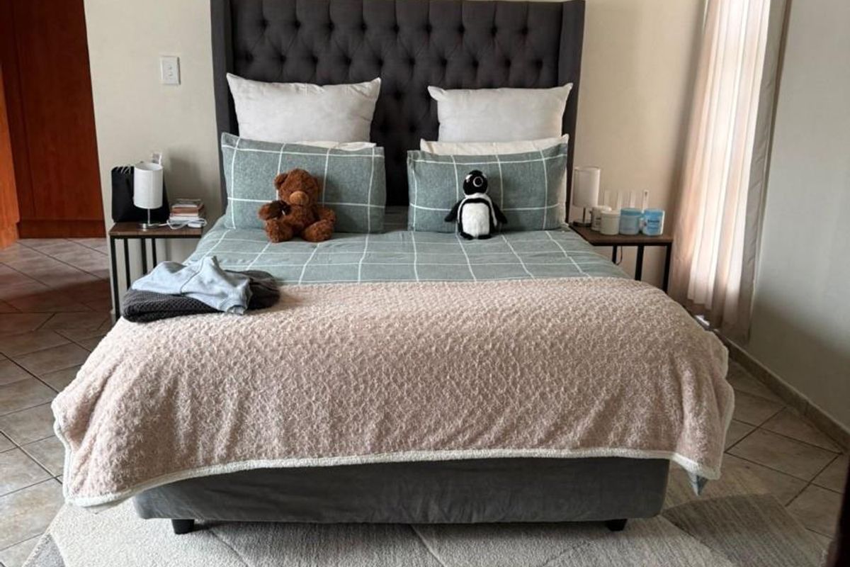 A well-maintained bedroom featuring tiled flooring and neutral wall finishes, providing a comfortable and functional living space.