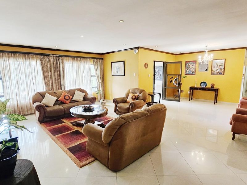 Spacious living room featuring polished tile flooring, recessed downlighting, and neutral wall finishes, offering a bright and open layout for comfortable family living.