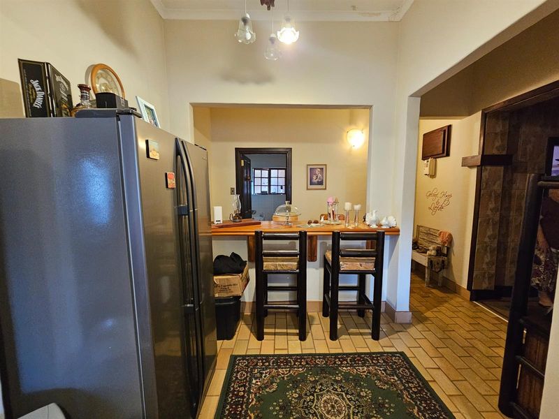 Open plan living area featuring a breakfast bar, tiled flooring, and direct access to adjacent rooms.