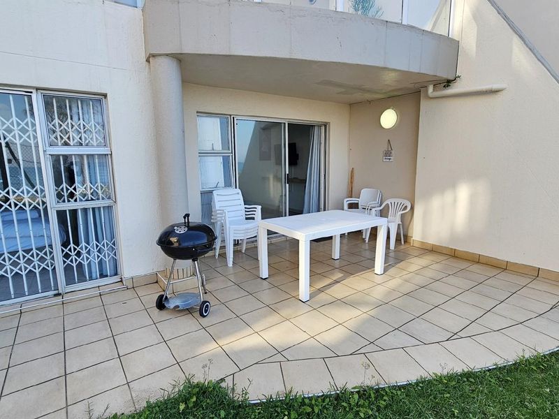 A covered patio area featuring tiled flooring and sliding glass door access to the apartment interior.