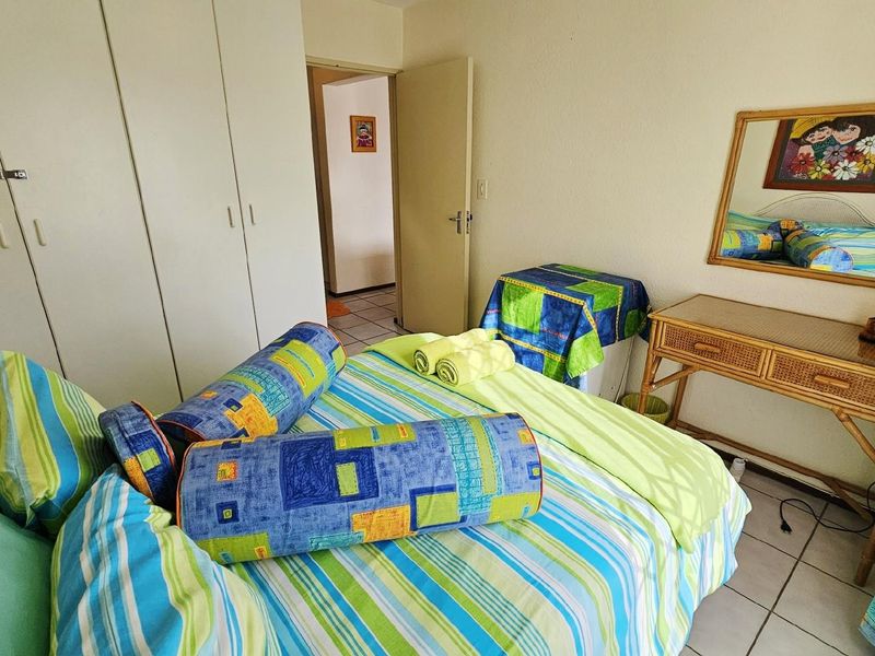 A bedroom featuring built-in cupboards and tiled flooring, providing a functional living space.