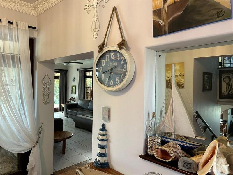 View from an entry area looking through to an open plan living space, featuring decorative ceiling cornicing and tiled flooring.