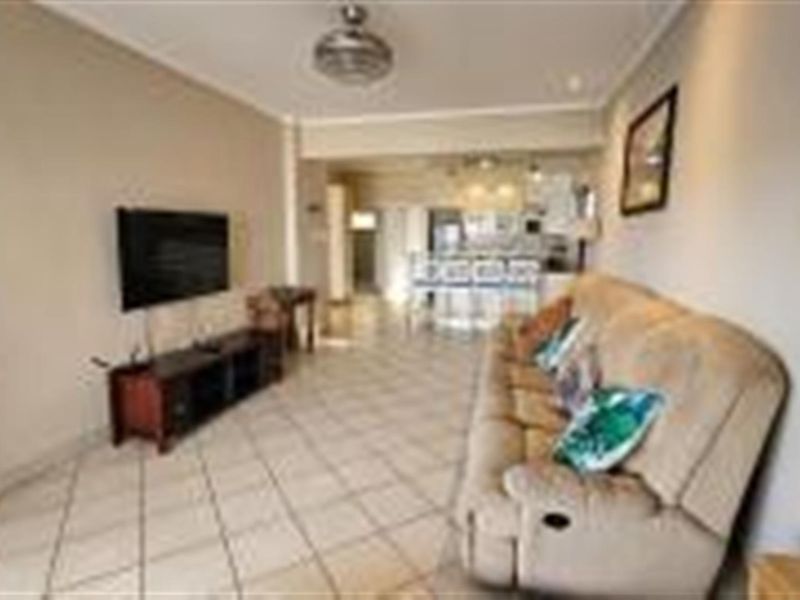 Open plan living area featuring tiled flooring and a seamless transition into the kitchen space.
