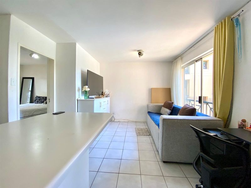 Open plan living area featuring tiled flooring and large sliding glass doors providing access to the balcony.