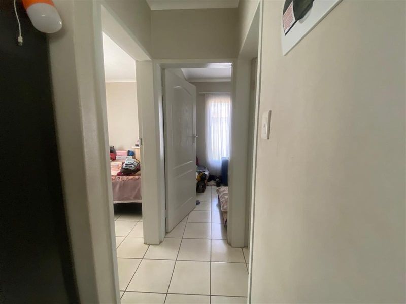 A view through a central hallway with tiled flooring, providing access to adjacent bedrooms.